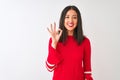 Young beautiful chinese woman wearing red dress standing over isolated white background smiling positive doing ok sign with hand Royalty Free Stock Photo