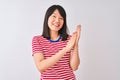 Young beautiful chinese woman wearing red striped t-shirt over isolated white background clapping and applauding happy and joyful, Royalty Free Stock Photo