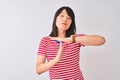 Young beautiful chinese woman wearing red striped t-shirt over isolated white background Doing time out gesture with hands, Royalty Free Stock Photo