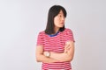 Young beautiful chinese woman wearing red striped t-shirt over isolated white background looking to the side with arms crossed Royalty Free Stock Photo