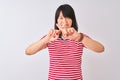 Young beautiful chinese woman wearing red striped t-shirt over isolated white background Rejection expression crossing fingers Royalty Free Stock Photo