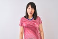 Young beautiful chinese woman wearing red striped t-shirt over isolated white background In shock face, looking skeptical and Royalty Free Stock Photo