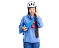 Young beautiful chinese woman wearing security helmet holding skate annoyed and frustrated shouting with anger, yelling crazy with