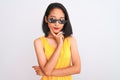 Young beautiful chinese woman wearing thug life sunglasses over isolated white background with hand on chin thinking about Royalty Free Stock Photo