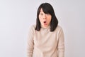 Young beautiful chinese woman wearing turtleneck sweater over isolated white background afraid and shocked with surprise Royalty Free Stock Photo