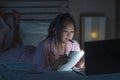 Young beautiful and confident Asian Korean student girl researching and studying at home preparing exam with laptop computer on Royalty Free Stock Photo