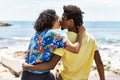 Young beautiful couple on back view kissing and sitting on the bench at the beach Royalty Free Stock Photo