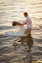 Young beautiful couple dancing in water with sunlight reflections Royalty Free Stock Photo