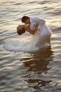 Young beautiful couple dancing in water with sunlight reflections Royalty Free Stock Photo