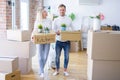 Young beautiful couple with dog moving cardboard boxes at new home Royalty Free Stock Photo