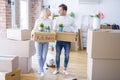 Young beautiful couple with dog moving cardboard boxes at new home Royalty Free Stock Photo