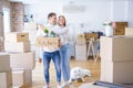 Young beautiful couple with dog moving cardboard boxes at new home Royalty Free Stock Photo