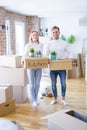 Young beautiful couple with dog moving cardboard boxes at new home Royalty Free Stock Photo