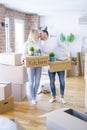 Young beautiful couple with dog moving cardboard boxes at new home Royalty Free Stock Photo