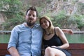 Young beautiful Couple enjoying an excursion in a small boat in a Canyon. Boy with black hair and white caucasian girl happy in a Royalty Free Stock Photo