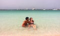 Young beautiful couple enjoys an early morning lonely bath in Espalmador beach, one of the most beautiful spots in Formentera.