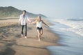 Young beautiful couple happily walking along the beach together