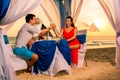 Young beautiful couple have a romantic dinner at sunset on a tropical beach . Honeymoon. Royalty Free Stock Photo