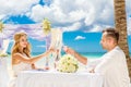 Young beautiful couple have a romantic dinner on a tropical beach . Wedding ceremony on a tropical beach. Wedding and honeymoon c Royalty Free Stock Photo