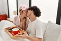 Young beautiful couple having breakfast on the bed at home Royalty Free Stock Photo