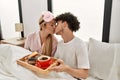 Young beautiful couple having breakfast on the bed at home Royalty Free Stock Photo