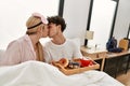 Young beautiful couple having breakfast on the bed at home Royalty Free Stock Photo