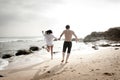 Young beautiful couple having fun jumping along beach Royalty Free Stock Photo