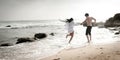 Young beautiful couple having fun jumping along beach Royalty Free Stock Photo