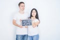 Young beautiful couple holding blackboard standing over isolated white background serious face thinking about question, very Royalty Free Stock Photo