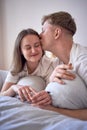 a young beautiful couple hugging and kissing in bed, wellness at home Royalty Free Stock Photo