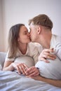 a young beautiful couple hugging and kissing in bed, wellness at home Royalty Free Stock Photo