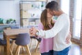 Young beautiful couple in love celebrating dancing moving to a new home, smiling very happy for new apartment