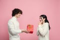 Young, beautiful couple in love on pink studio background. Valentine's Day, love and emotions concept Royalty Free Stock Photo