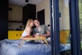 Young beautiful couple in love is sitting in bed and having healthy breakfast together. Royalty Free Stock Photo