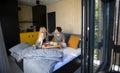 Young beautiful couple in love is sitting in bed and having healthy breakfast together. Royalty Free Stock Photo