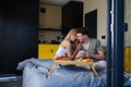 Young beautiful couple in love is sitting in bed and having healthy breakfast together. Royalty Free Stock Photo