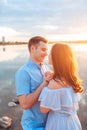 Young beautiful couple in love staying and kissing on the beach on sunset. Soft sunny colors. Royalty Free Stock Photo