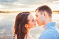 Young beautiful couple in love staying and kissing on the beach on sunset. Soft sunny colors. Royalty Free Stock Photo