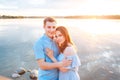 Young beautiful couple in love staying and kissing on the beach on sunset. Soft sunny colors. Royalty Free Stock Photo