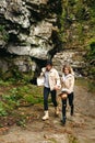 Young and beautiful couple at the mountain waterfall - Happy tourists visiting mountains. Lovestory. Tourists in hats. Military