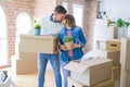 Young beautiful couple moving cardboard boxes and kissing at new home Royalty Free Stock Photo