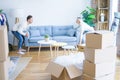 Young beautiful couple moving sofa at new home around cardboard boxes Royalty Free Stock Photo