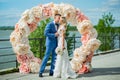 Young beautiful couple of newlyweds bride and groom during a wedding ceremony on the beach near the large arch dress rings. Love Royalty Free Stock Photo