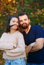 Young beautiful couple in the Park. They fool around and have fun. They make false mustaches out of hair. They are illuminated by Royalty Free Stock Photo