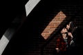 Young beautiful couple in plaid shirts against a brick wall of home. The light from window creates shadows. Royalty Free Stock Photo