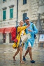 Young beautiful couple in raincoats on walk through city. Feeling amused and joyful, woman pointing forward. Travel, togetherness Royalty Free Stock Photo