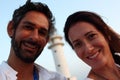 Young beautiful couple's portrait with Cap de Barberia's lighthouse on soft background, Formentera. Royalty Free Stock Photo