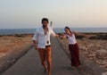 Young beautiful couple`s portrait with Cap de Barberia`s lighthouse on soft background, Formentera, Balearic Islands, Spain