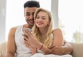 Young Beautiful Couple Sit On Coach Near Window, Using Cell Smart Phone Happy Smile Hispanic Man Woman Royalty Free Stock Photo