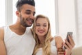 Young Beautiful Couple Sit On Coach Near Window, Using Cell Smart Phone Happy Smile Hispanic Man Woman Royalty Free Stock Photo